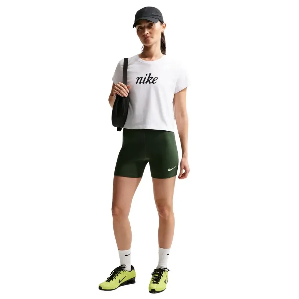 Vista lateral da blusa branca Nike usada por mulher com shorts verde e tênis